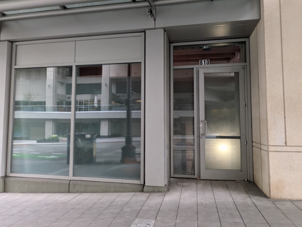 810 Pike Street. The address is the only marking. The door is propped open — construction is happening behind it. May 6, 2026.