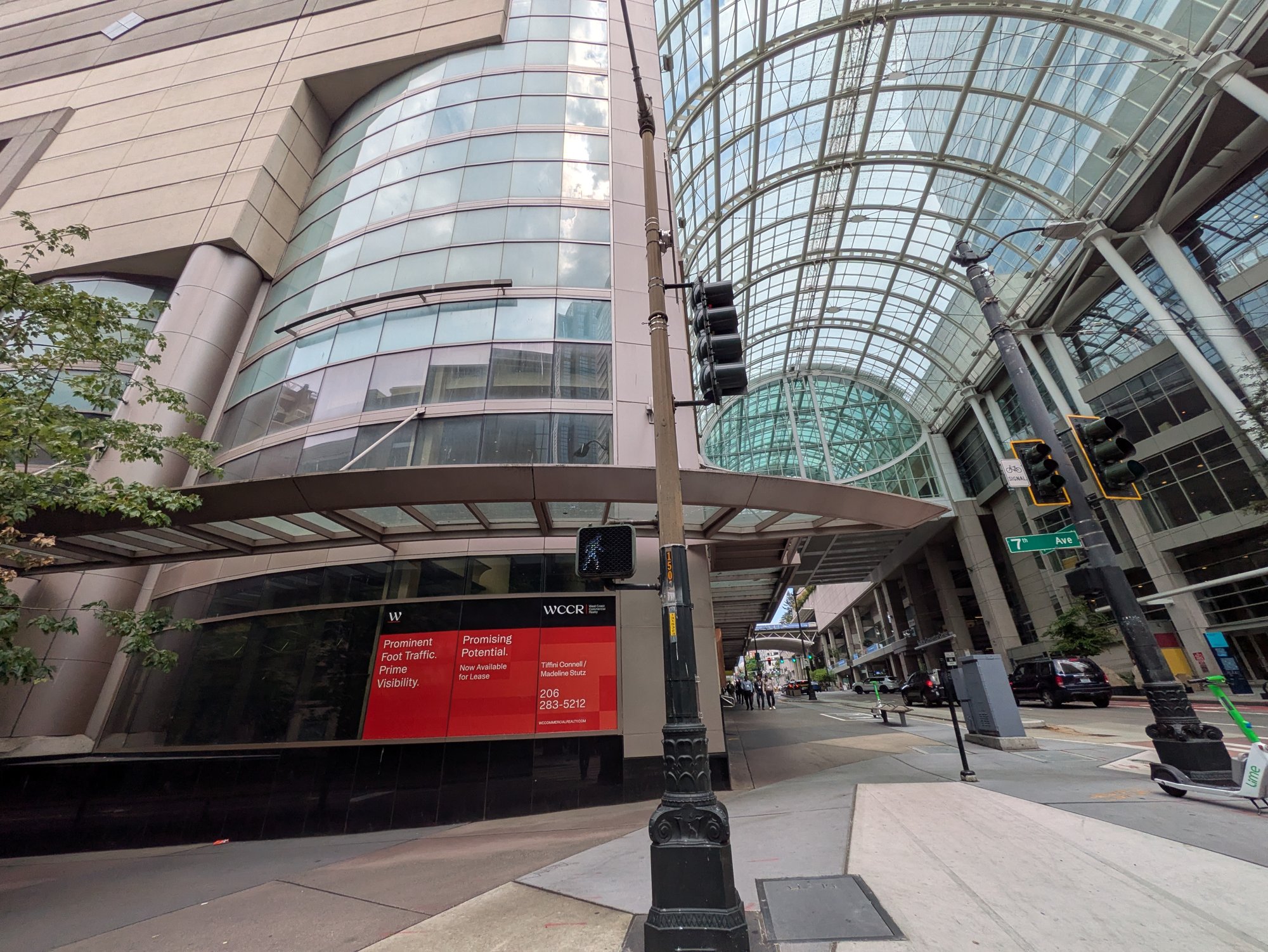 Across the street, the convention center's own ground-floor retail sits empty behind a leasing sign promising prominent foot traffic — the exact thing the math says isn't reliably there.